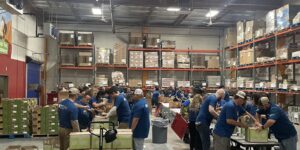 St. Mary's volunteers shown in large warehouse-type building working.